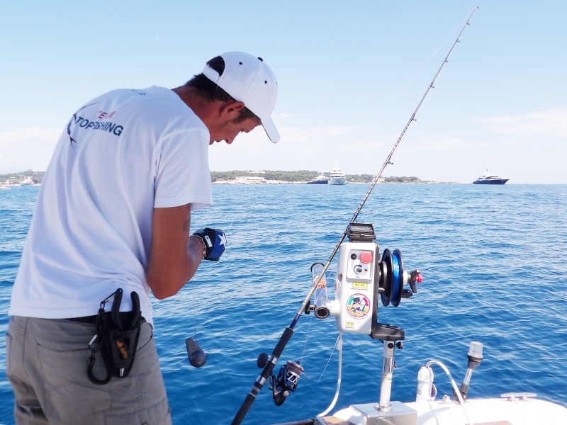 Le moniteur guide de pêche Fabien Harbers en train d’installer un calamar en vif sur son downrigger Kristal Fishing