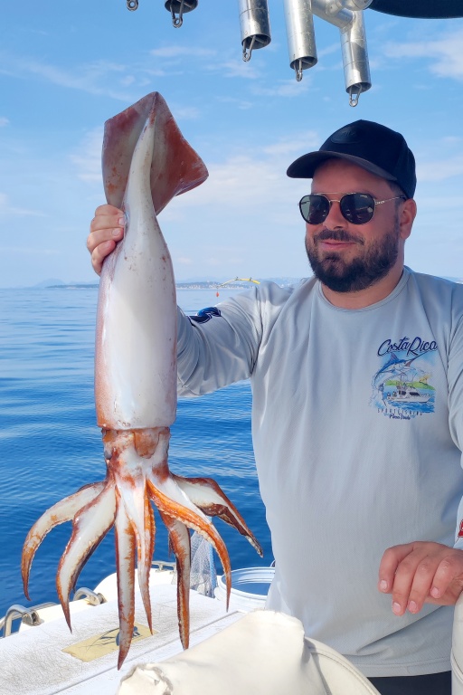 Un des stagiaires du guide de pêche Fabien Harbers avec un énorme calamar rouge pris à la turlutte-appâts !