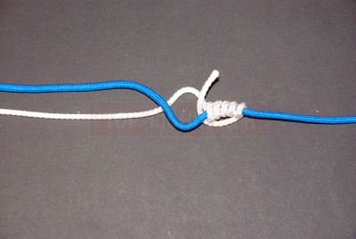 Ramenez le brin et le faire passer dans l\'espace. Maintenez le avec le pouce afin qu\'il ne se défasse pas.