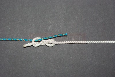 Passez la tresse dans la première spire du 8 par rapport au bout de fluorocarbone. Vous partez du haut vers le bas.